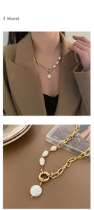 Close-up of baroque pearl pendant necklace with gold chain and circular spring clasp