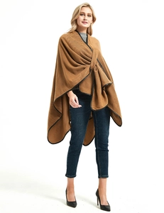 Brown knit poncho wrap with black leather trim detail and a stylish cross-front buckle