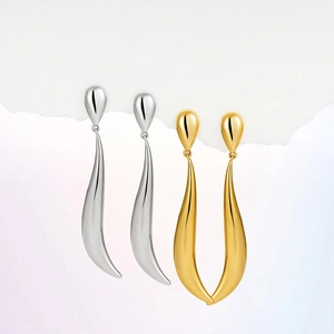 Detail of 18k gold and silver sleek water drop earrings with a minimal curved line design