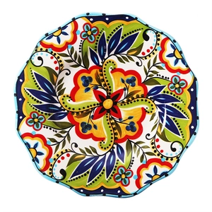 Hand-painted ceramic plate with wavy edges and vibrant floral patterns on white background