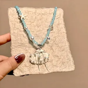 Detailed macro view of sea shell pendant necklace with blue beads and pearls