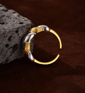Detailed close-up of a two-tone twisted silver ring with a gold brushed texture finish