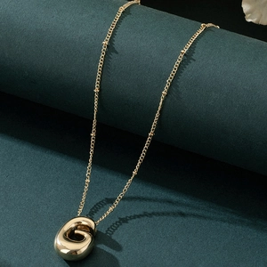 Detailed view of golden balloon-style letter G pendant on a minimalist chain