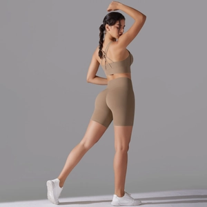 Vista dettagliata del set yoga kaki con reggiseno sportivo incrociato e pantaloncini a vita alta