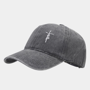 Detail view of white faith embroidery and cross on charcoal washed cotton baseball cap