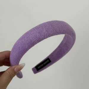 Detail of a purple sponge headband with soft towel texture and handmade label