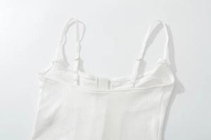 Gros plan d'un camisole blanc en maille côtelée avec de fines bretelles réglables