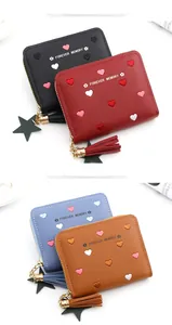 Detail of colorful heart embroidery and tassel charm on zip wallets in four colors
