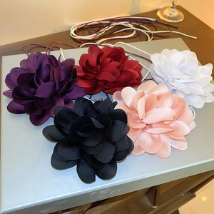 Five assorted fabric camellia flower necklaces in purple, red, white, black, and pink
