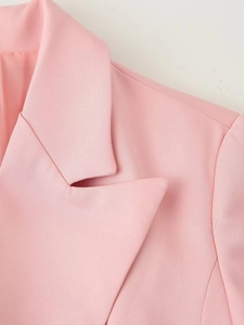 Close-up of pink blazer lapel showing fine woven texture and premium shoulder tailoring