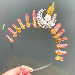 Macro detail of handmade silver headband with orange crystal pillars and moon moon charm