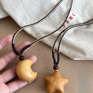 Handcrafted wooden moon and star pendant necklace on a braided rope cord
