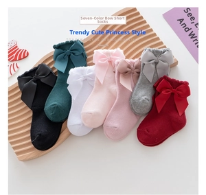 Detail of seven pairs of colorful princess cotton socks with large ribbon bows for girls
