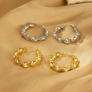 Detailed close-up of twisted rope hoop earrings with inlaid rhinestones on satin
