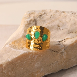 French design gold titanium steel ring with three irregular green stones on stone base