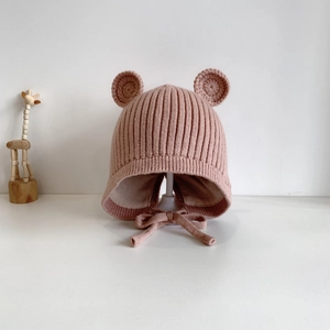 Detail der rosa Baby-Strickmütze mit süßen Bärenohren und gerippter Textur mit Ohrenklappen