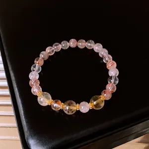 Elegant natural citrine bracelet with gold filigree spacers on black leather background