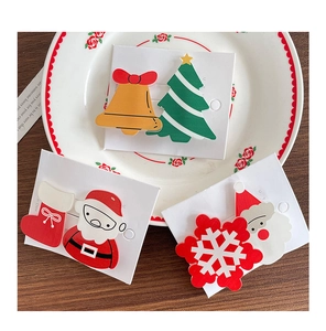 Detailed close-up of a Christmas hair clip set featuring Santa Claus and tree patterns