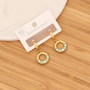 Gold stainless steel evil eye hoop earrings on a display card with a wood background