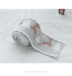 Close-up of grey linen Christmas ribbon with white reindeer and sparkly tree motifs