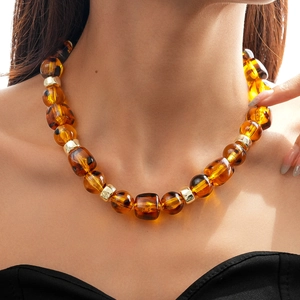 Macro shot of vintage amber acrylic heart beads and golden metal spacers on a necklace