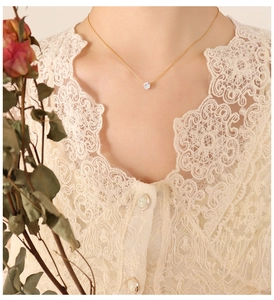 Detail shot of a minimal 18K gold plated titanium chain necklace with a single round zircon