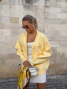 French style light yellow knit cardigan with white dress and quilted handbag
