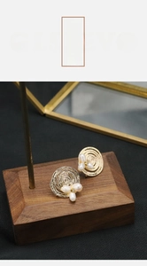 Macro shot of 18k gold plated spiral stud earrings with white natural pearls details