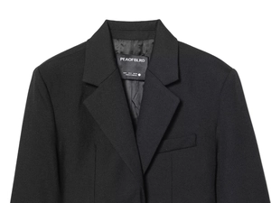 Detail view of black vintage suit jacket lapel with woven label and twill fabric texture