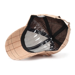 Inside view of plaid baseball cap showing 100% cotton label and black sweatband