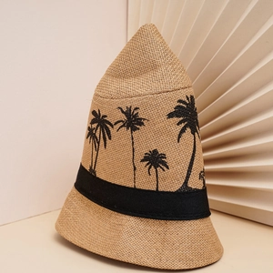 Détail d'un chapeau cloche en paille avec broderie de cocotier noir et ruban décoratif chic