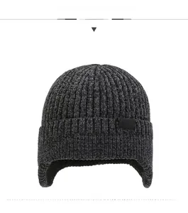 Detail of dark grey knit ear protection hat with thick ribbed texture and SPORT tag