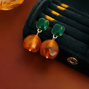 French vintage earrings with green square studs and amber resin beads on black tray