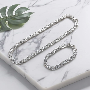 Byzantine link chain necklace and bracelet set in silver stainless steel on marble base