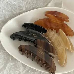 Vista ravvicinata di quattro eleganti mollette per capelli su vassoio in ceramica