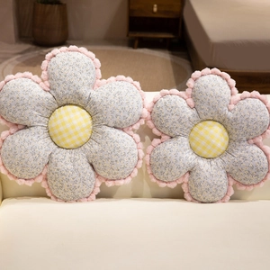 Floral-shaped plush cushions with blue floral petals and yellow plaid centers on sofa