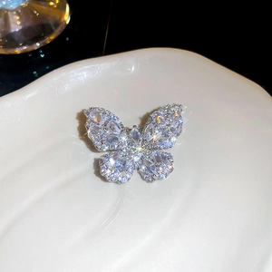 Macro shot of silver butterfly brooch featuring shimmering cubic zirconia in micro-pave setting