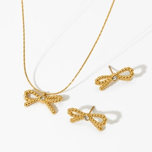 Détail de l'ensemble collier et boucles d'oreilles nœud doré avec cristaux clairs