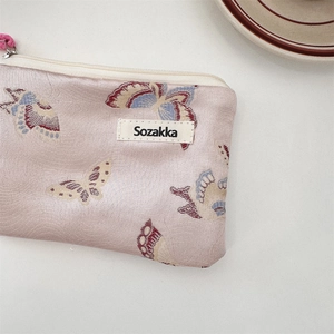 Close-up of pink jacquard butterfly shoulder bag with Sozakka label and zipper