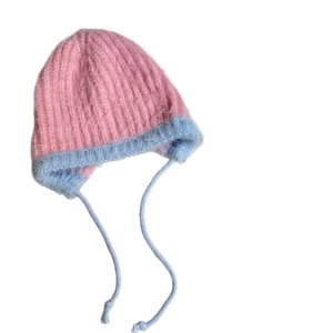 Winter plush knit hat for girls with ear flaps and blue ties on a white background
