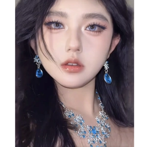 Detail of zircon hollow flower necklace and teardrop tassel earrings on model