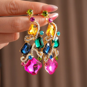 Close-up of vintage gold earrings with large colorful gemstones and sparkling crystals