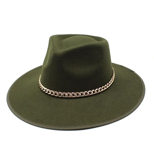 Détail d'un fedora en laine vert foncé avec bord plat et chaîne en métal doré chic