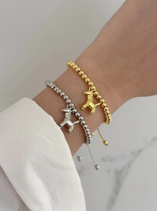 Stackable gold and silver beaded bracelets with unicorn charms on a model's wrist