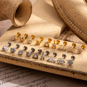 Detailed arrangement of gold and silver titanium labret studs with inlaid zircon shapes