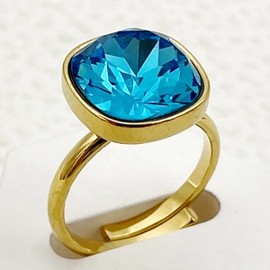 Gros plan détaillé d'une bague en acier inoxydable doré avec un zircon bleu de forme carrée