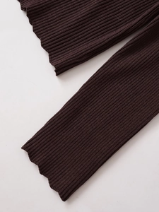 Detailed view of dark brown ribbed knit fabric with delicate lettuce edge hem