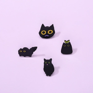 Set of four cute black cat enamel pins with various expressions on purple background