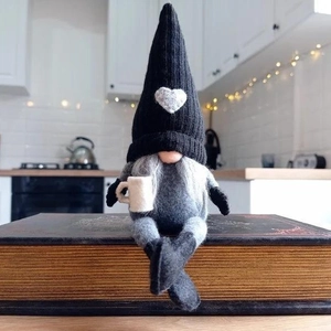 Nordic knitted gnome plush decor with heart hat sitting on a vintage book