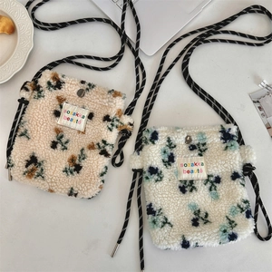 Dettaglio della borsa a tracolla in peluche floreale con tessuto materico e magnete